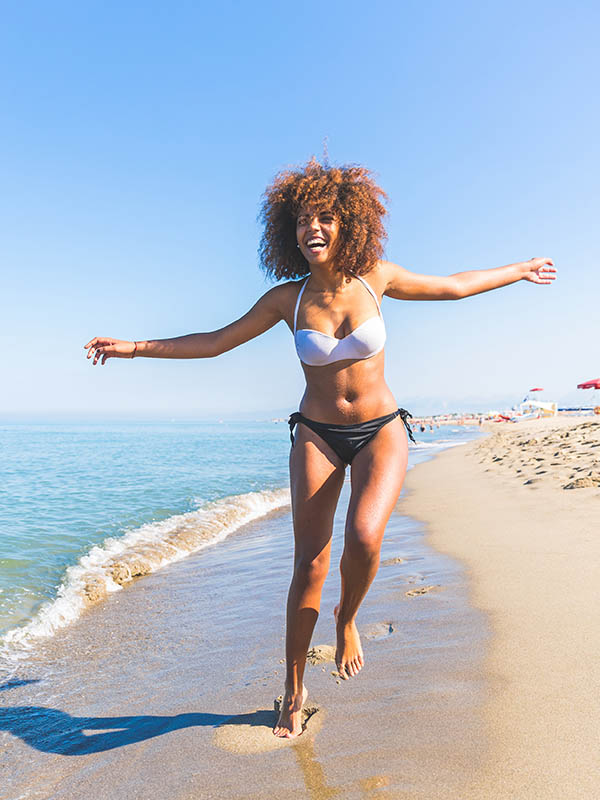 Young black woman having fun at seaside